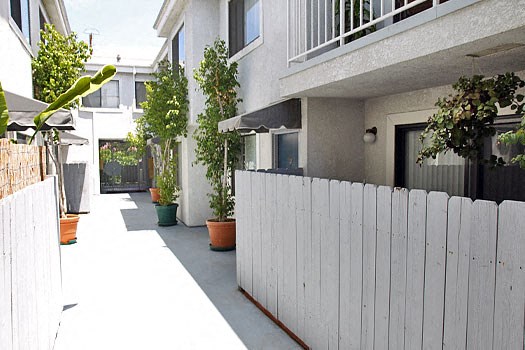 a white picket fence in front of an apartment building