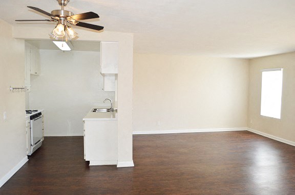 an empty kitchen and living room with a ceiling fan