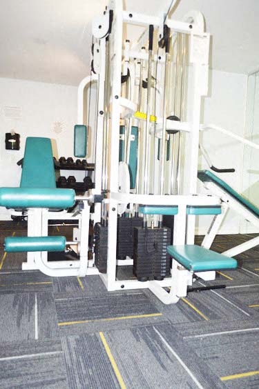 a gym with some weights and chairs in it