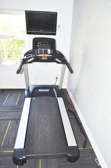 a treadmill in a room with a tv on top of it