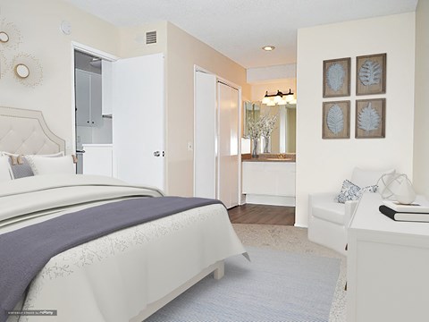 a white and blue bedroom with a bed and a bathroom