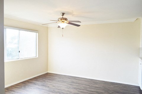 an empty room with a ceiling fan and a window