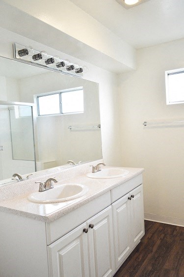 an empty bathroom with two sinks and a mirror