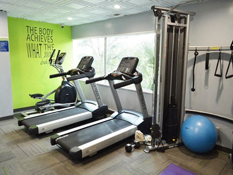 a gym with exercise equipment and a large window