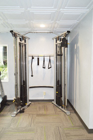 a gym with weights and equipment in a white room