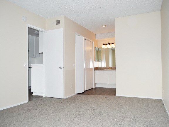 an empty living room with an open door to a bathroom
