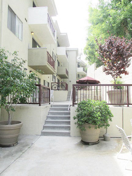 an apartment building with stairs and potted plants