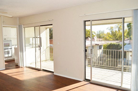 an empty living room with sliding glass doors to a balcony
