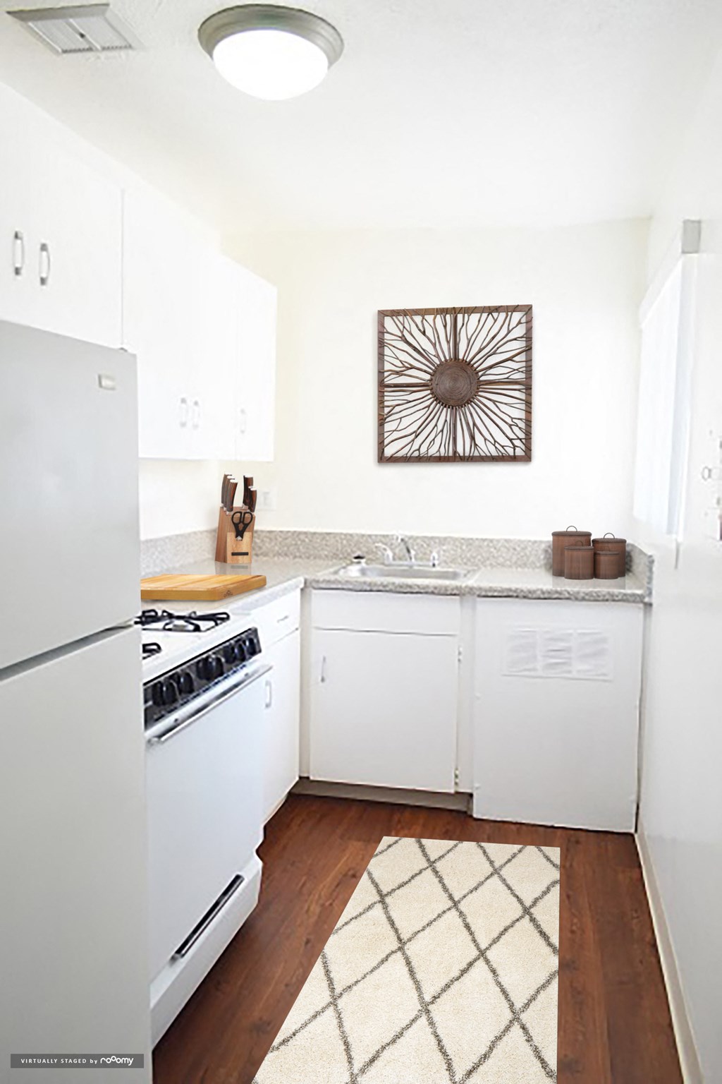 a white kitchen with white appliances and a rug