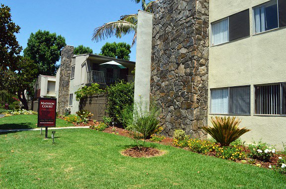 an apartment building with a sign in the grass
