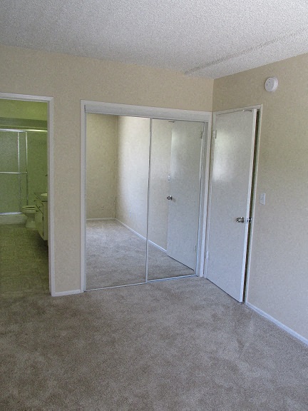 an empty room with a bathroom and a closet