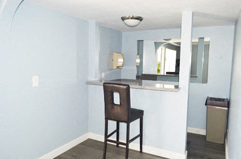 a bar in a room with a chair and a mirror