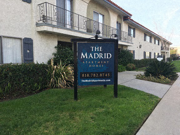a sign in the grass in front of a building
