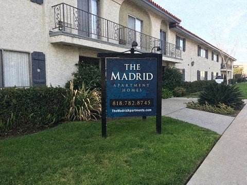 a sign in the grass in front of a building