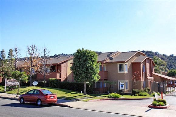 a red car parked in front of an apartment building