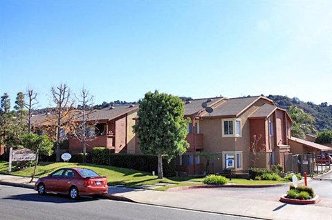 a red car parked in front of an apartment building