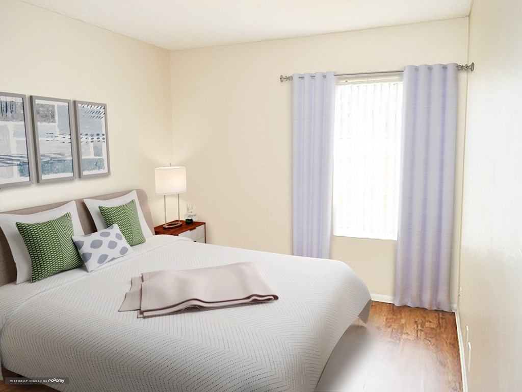 a bedroom with a white bed and white and green pillows