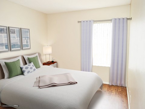 a bedroom with a white bed and white and green pillows