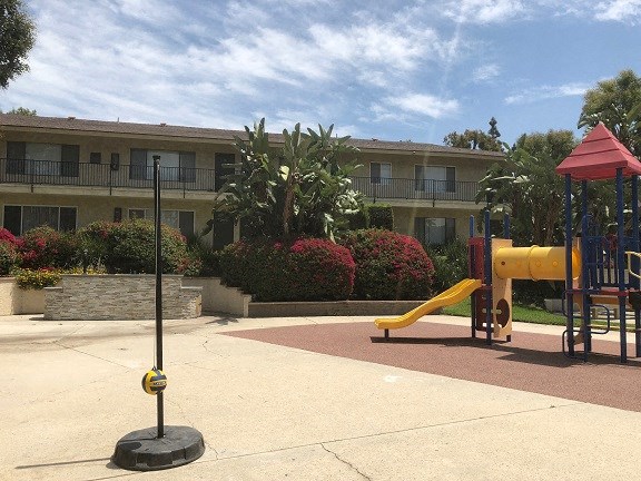 a playground in a park in front of an apartment building