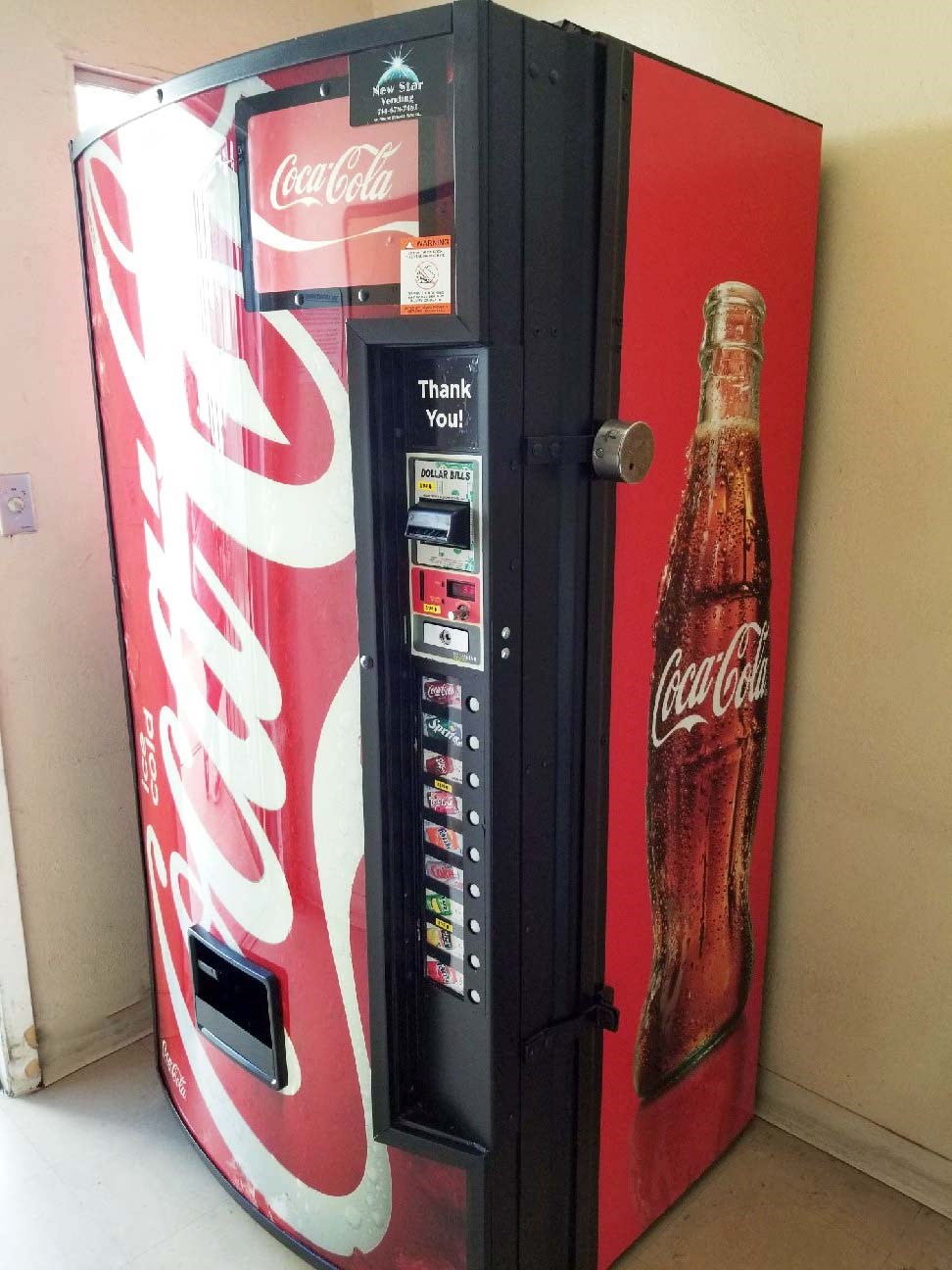 a coca cola vending machine with a coke bottle