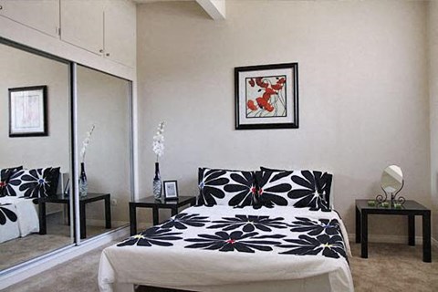 a bedroom with a bed and a picture on the wall