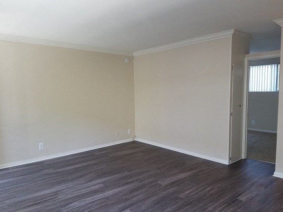 an empty living room with wood floors and a door