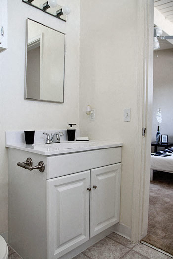 a white bathroom with a sink and a mirror