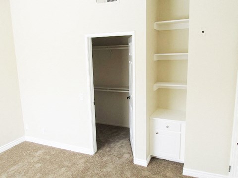 an empty closet with shelves and a door open to a closet