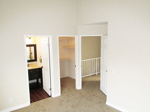 an empty living room with a staircase and a closet
