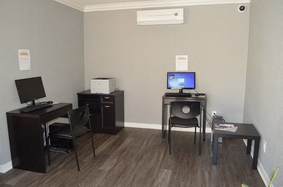 a room with a computer and a table with chairs