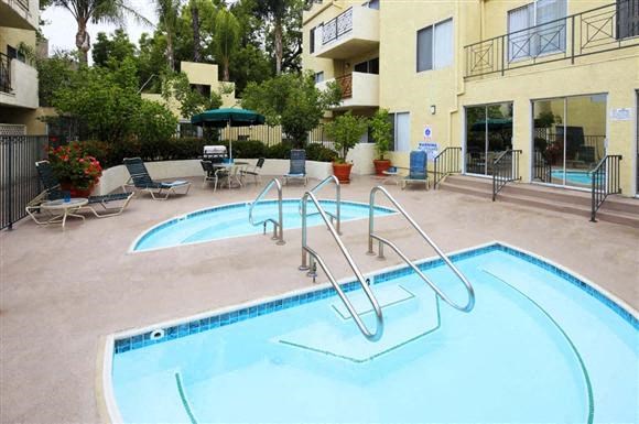 a large swimming pool in front of an apartment building