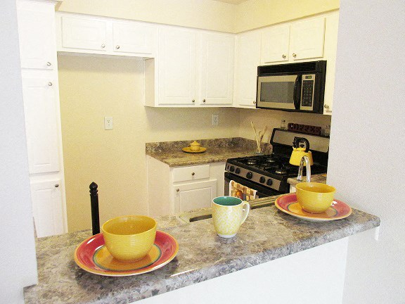 a kitchen with coffee cups on a counter