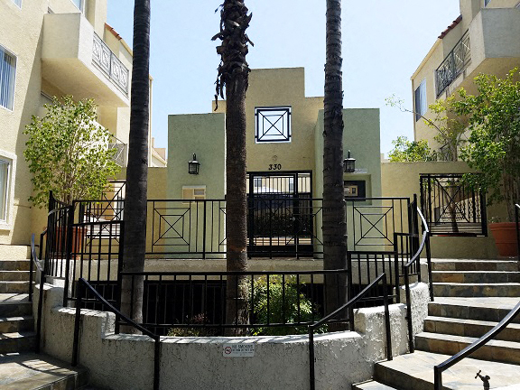 a building with stairs and trees in front of it