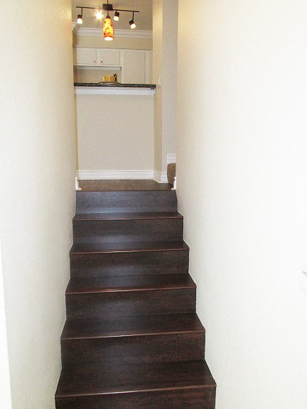 a staircase in a house with a white kitchen