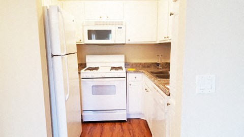 a kitchen with white appliances and white cabinets