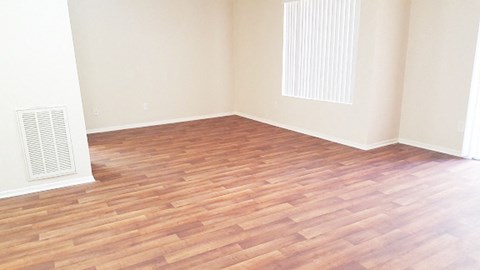 an empty room with a hardwood floor and a radiator