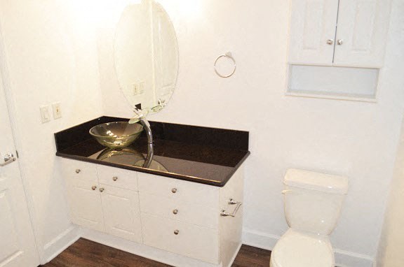 a bathroom with a black counter top and a toilet