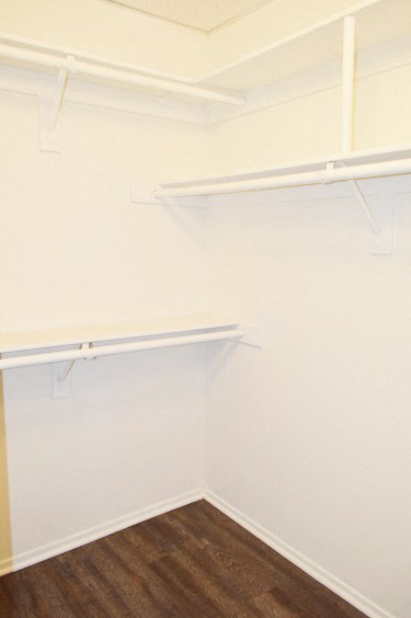 an empty closet in a room with white walls and shelves