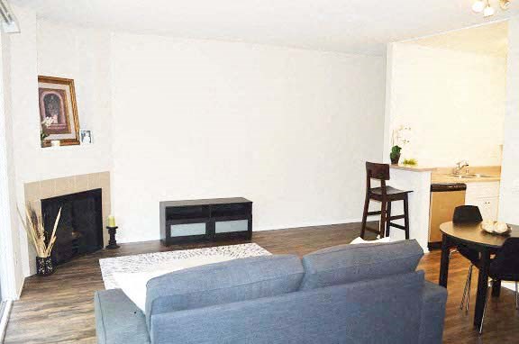 a living room with a blue couch and a fireplace