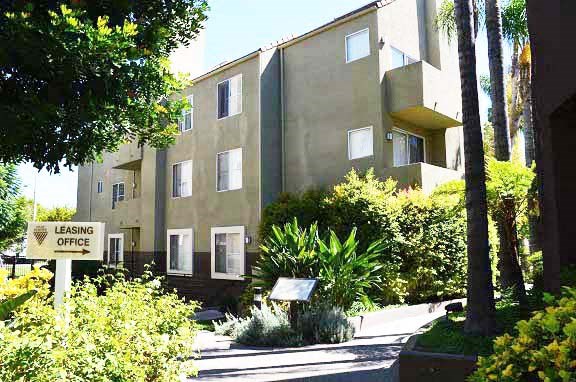 an apartment building with a leasing office sign in front of it