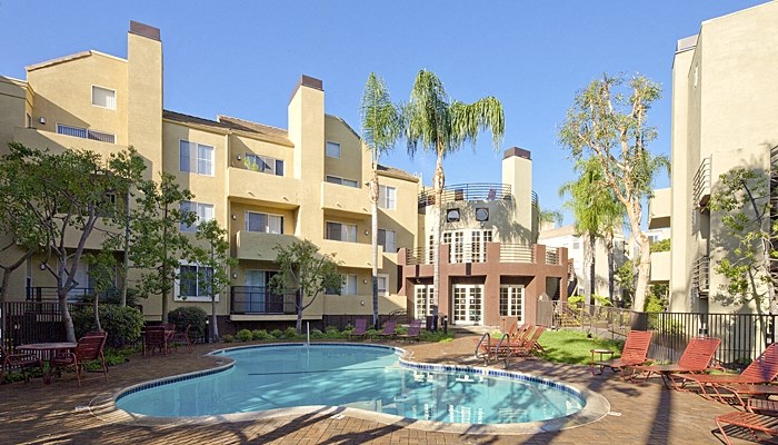 a large swimming pool in front of an apartment building