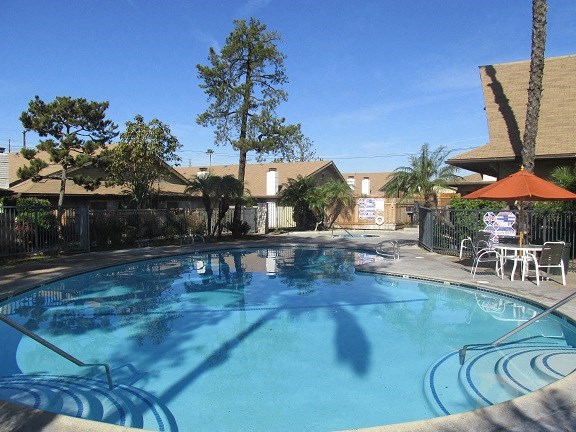 a large swimming pool with tables and chairs around it