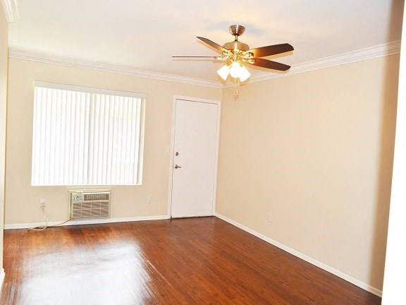 an empty living room with a ceiling fan and a window