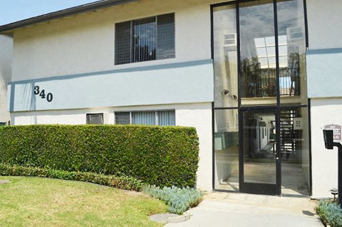 a building with a sidewalk and a glass door