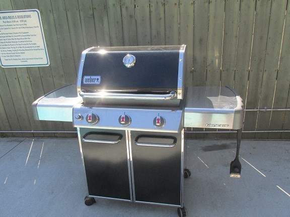 a grill and a table in front of a fence