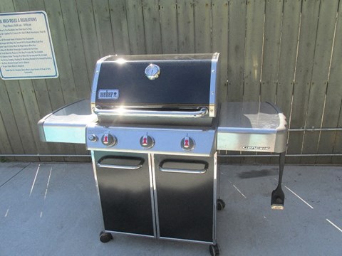 a grill and a table in front of a fence
