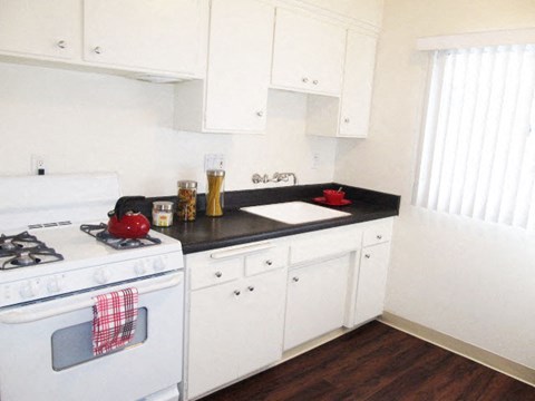 a white kitchen with a stove and a sink