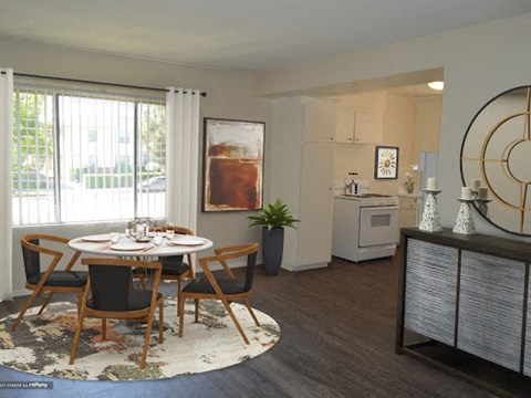 a living room and dining room with a table and chairs