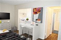 a living room with a white desk and a television