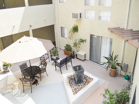 a courtyard with a table and chairs and a fountain